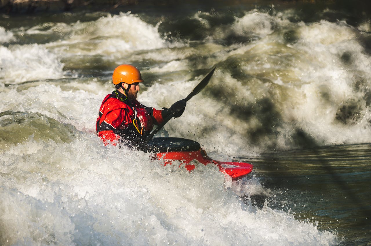 Man kayaking through whitewater rapids, showcasing adventure and outdoor excitement.