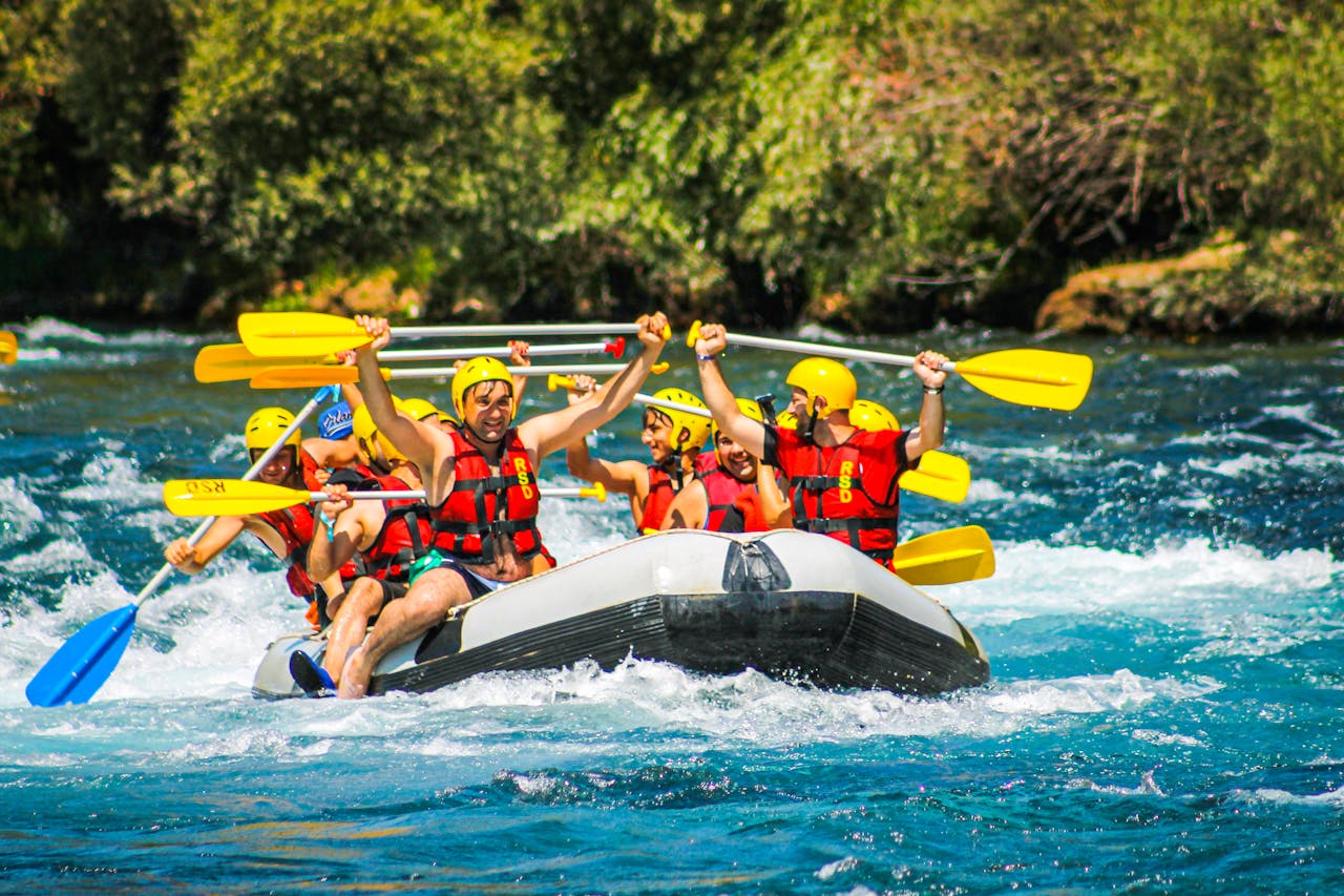Group of friends enjoying an exhilarating river rafting adventure outdoors.