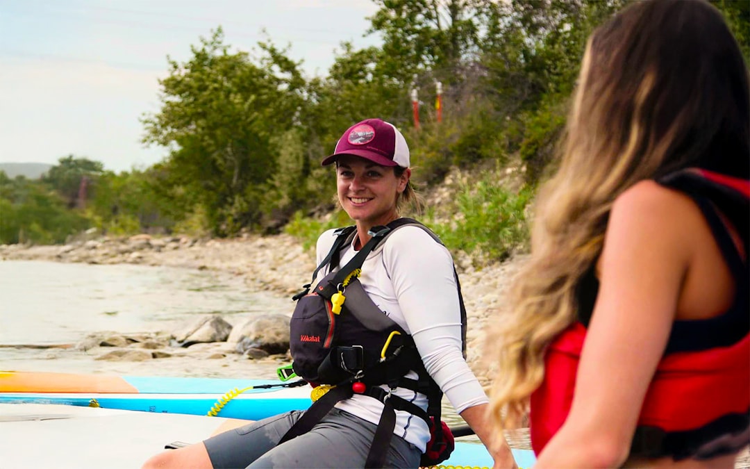two-women-prepare-to-paddleboard-oxstg0xzxso